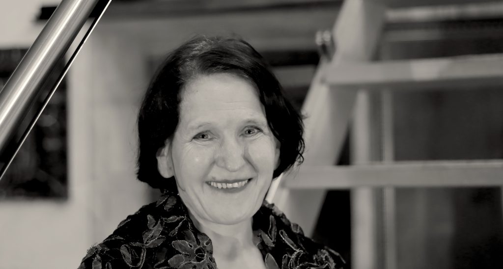 freie Mitarbeiterin Barbara Lucassen, lächelnde Frau an Treppe